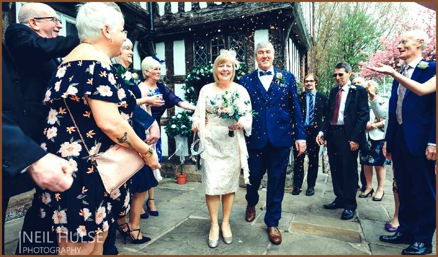 A happy wedding party throwing confetti outside the hall